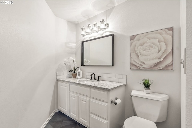 bathroom featuring vanity, toilet, and baseboards