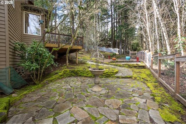 view of yard with a deck, a patio area, and a fenced backyard