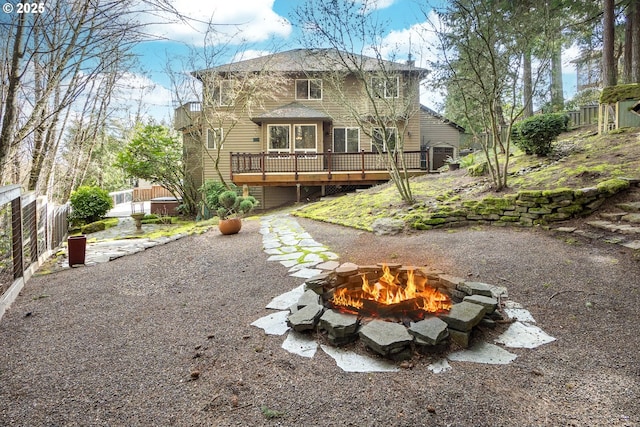 view of front of property featuring an outdoor fire pit, fence, and a wooden deck