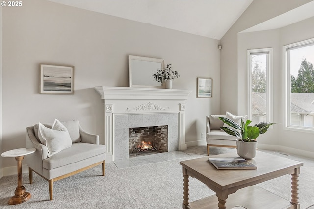 sitting room with vaulted ceiling, carpet floors, a fireplace, and baseboards