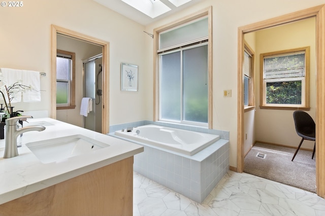 1249 Crenshaw Rd, Eugene, OR 97401 - bathroom featuring healthy amount of natural light, a bath, marble look tiles, and a skylight