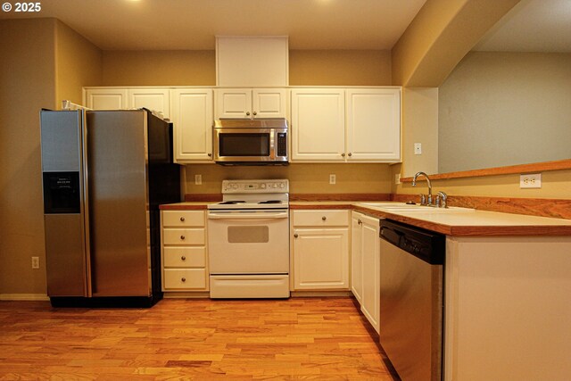 kitchen featuring sink, white cabinets, stainless steel appliances, and light hardwood / wood-style flooring