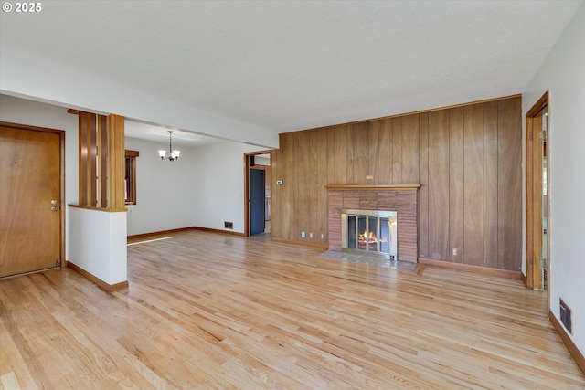 4133 SE Henderson St, Portland, OR 97202 - unfurnished living room with visible vents, light wood finished floors, a brick fireplace, and baseboards