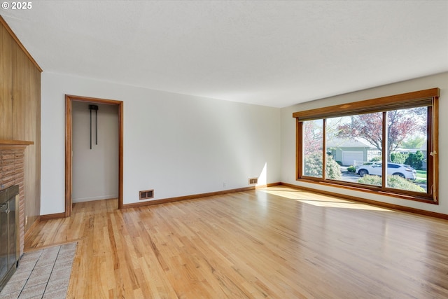 4133 SE Henderson St, Portland, OR 97202 - unfurnished living room with a fireplace with flush hearth, baseboards, light wood finished floors, and visible vents