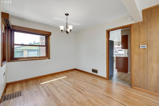 4133 SE Henderson St, Portland, OR 97202 - empty room with baseboards, visible vents, an inviting chandelier, and light wood-style floors