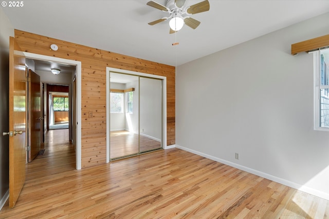 4133 SE Henderson St, Portland, OR 97202 - unfurnished bedroom featuring wooden walls, ceiling fan, light wood-style flooring, baseboards, and a closet