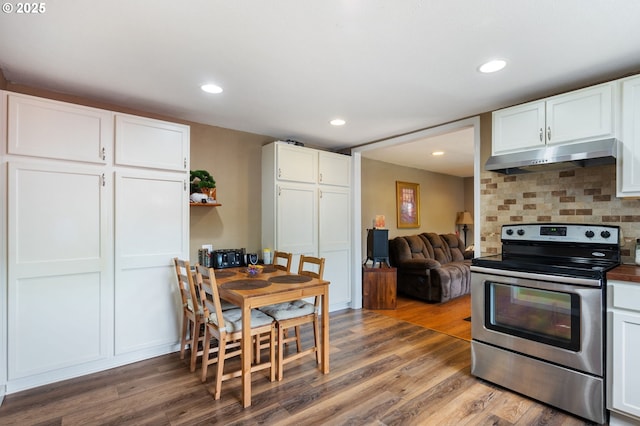 9819 SE Knight St, Portland, OR 97266 - kitchen with stainless steel electric stove, under cabinet range hood, wood finished floors, white cabinets, and recessed lighting