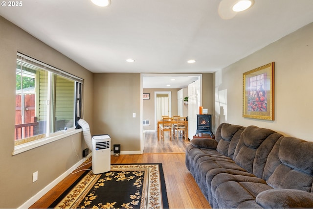 9819 SE Knight St, Portland, OR 97266 - living room with wood finished floors, a wood stove, and recessed lighting
