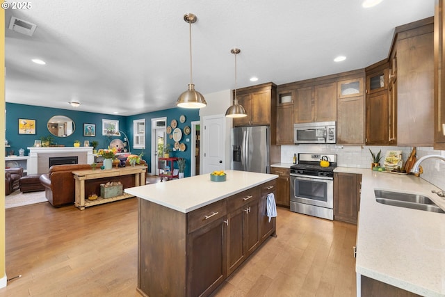 14665 Catalpa Way, Oregon City, OR 97045 - kitchen with appliances with stainless steel finishes, a sink, open floor plan, light wood-style flooring, and recessed lighting