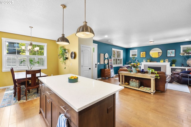 14665 Catalpa Way, Oregon City, OR 97045 - kitchen with a textured ceiling, light wood finished floors, light countertops, a kitchen island, and open floor plan