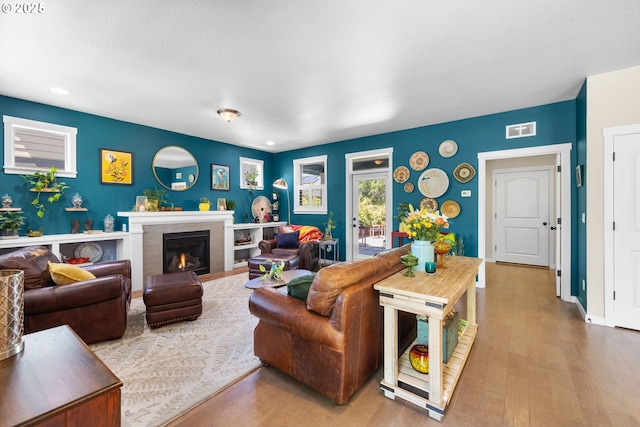 14665 Catalpa Way, Oregon City, OR 97045 - living area with wood finished floors, a warm lit fireplace, recessed lighting, and baseboards