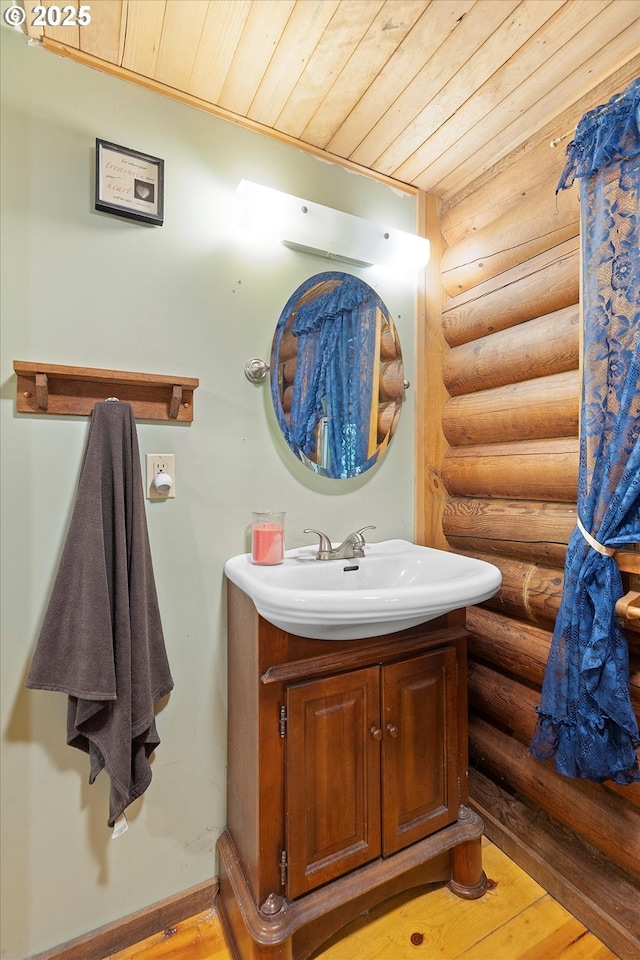 4347 S Schooner Creek Rd, Lincoln City, OR 97367 - bathroom featuring rustic walls, wooden ceiling, vanity, and hardwood / wood-style floors