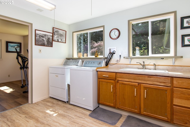 471 Barr Rd, Grays River, WA 98621 - laundry area featuring a sink, cabinet space, light wood-type flooring, and washing machine and clothes dryer