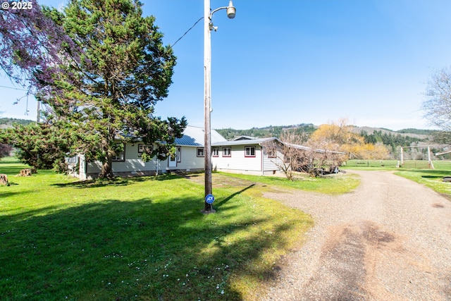 view of front of property featuring a front lawn, dirt driveway, and crawl space