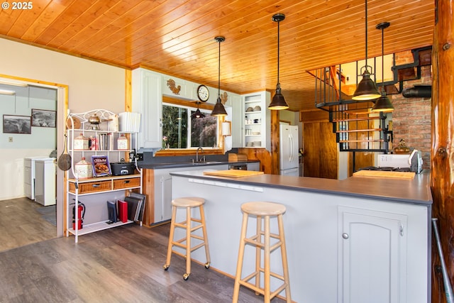 kitchen with independent washer and dryer, open shelves, freestanding refrigerator, wood ceiling, and dark wood-style flooring