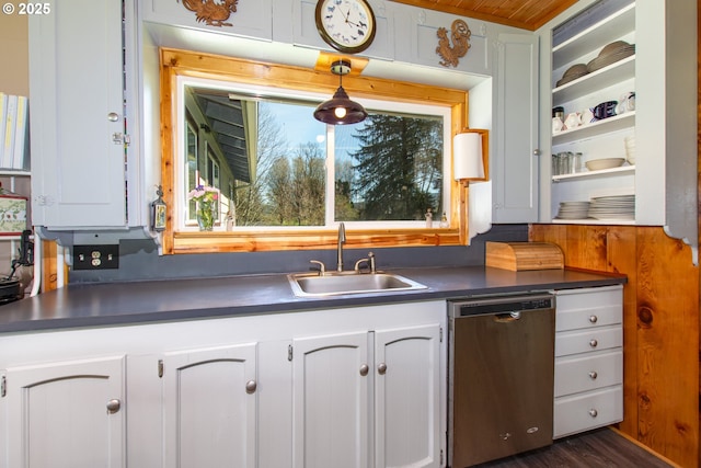 kitchen with white cabinetry, open shelves, a sink, stainless steel dishwasher, and dark countertops