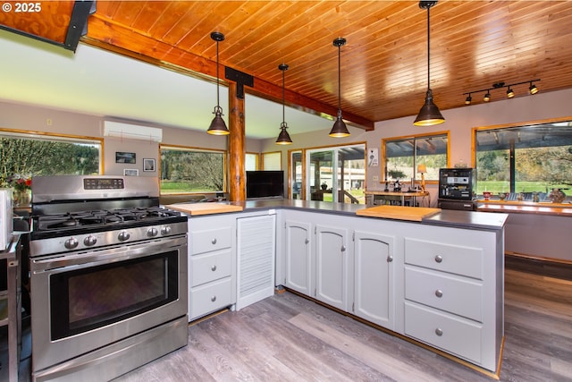 kitchen featuring gas range, white cabinets, wood finished floors, and wooden ceiling