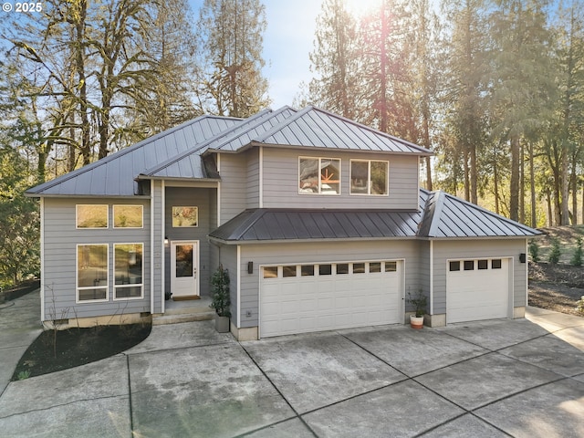 view of front of house with driveway, a standing seam roof, a garage, and metal roof