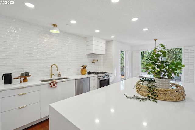 kitchen featuring modern cabinets, custom range hood, appliances with stainless steel finishes, light countertops, and a sink