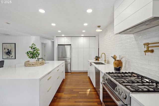 kitchen with dark wood-style flooring, stainless steel appliances, white cabinets, a sink, and modern cabinets