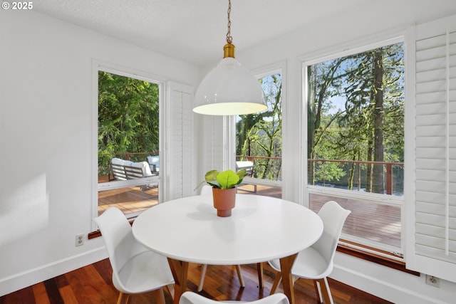 dining area featuring dark wood-type flooring, a textured ceiling, and baseboards