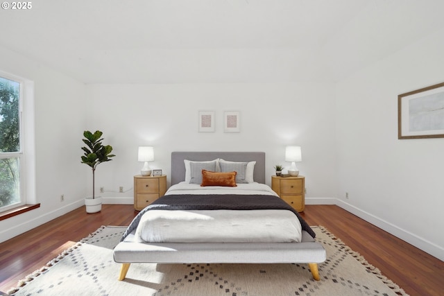 bedroom featuring multiple windows, wood finished floors, and baseboards