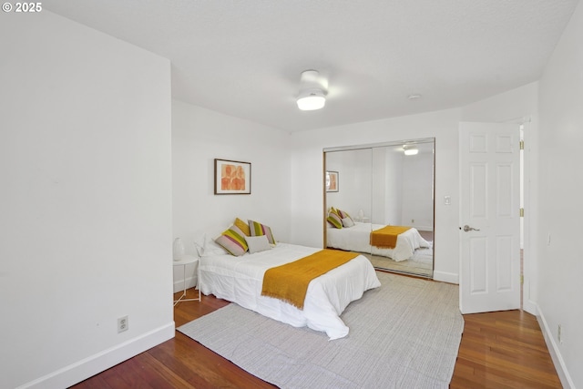 bedroom with a closet, baseboards, and wood finished floors