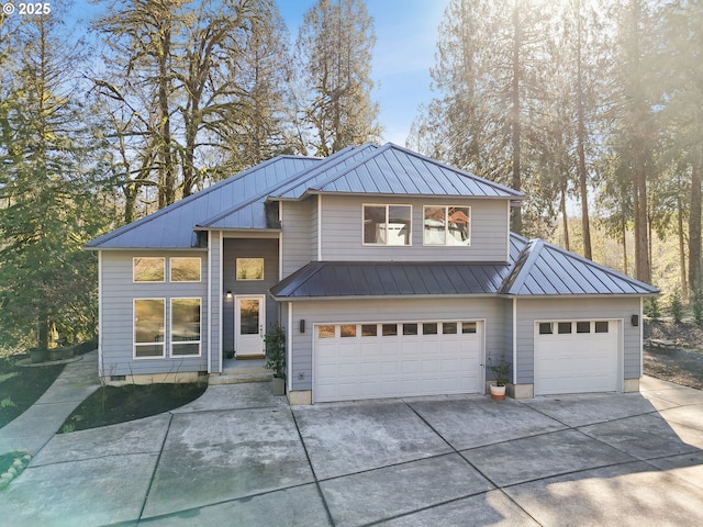 view of front of property featuring metal roof, a standing seam roof, and driveway