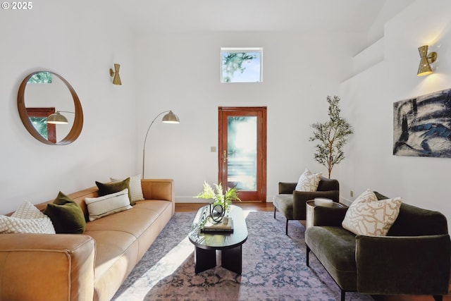 living room featuring a towering ceiling and wood finished floors