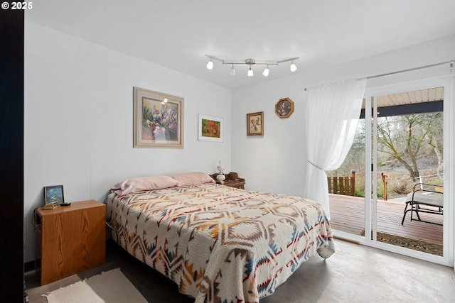 bedroom featuring access to exterior and concrete floors