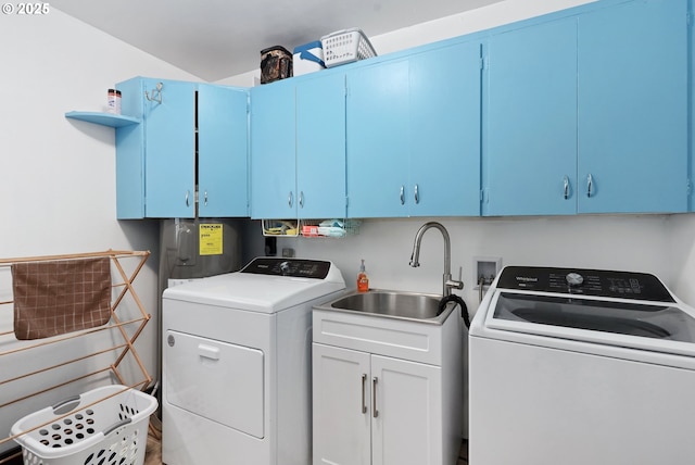 clothes washing area with cabinets, sink, washer and clothes dryer, and water heater