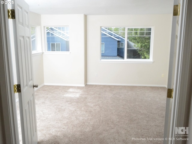 empty room with carpet floors, baseboards, and plenty of natural light
