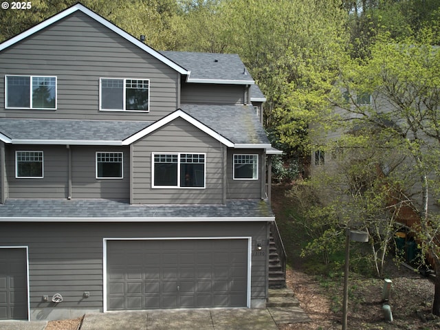 view of front of property featuring an attached garage and roof with shingles