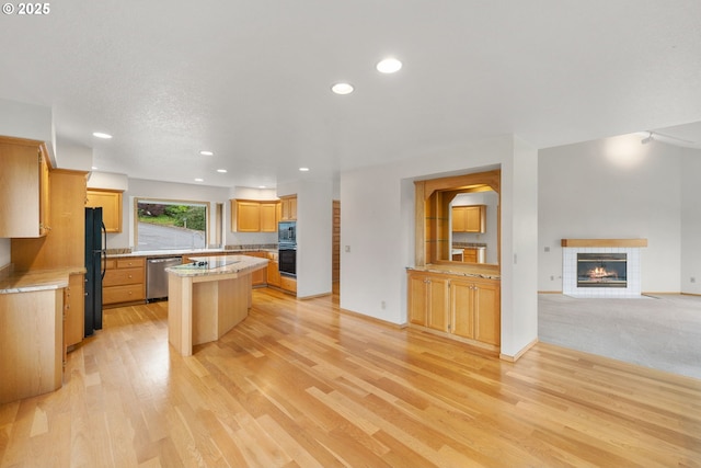 2305 Chickadee Ct, West Linn, OR 97068 - kitchen featuring black appliances, a fireplace, light countertops, light wood-style flooring, and recessed lighting