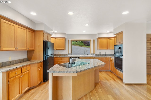 2305 Chickadee Ct, West Linn, OR 97068 - kitchen with black appliances, a center island, a sink, light wood-type flooring, and recessed lighting