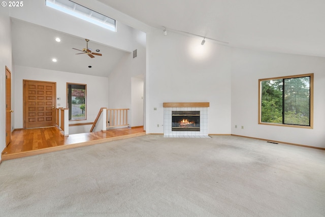 2305 Chickadee Ct, West Linn, OR 97068 - unfurnished living room with carpet floors, high vaulted ceiling, a ceiling fan, baseboards, and a tile fireplace
