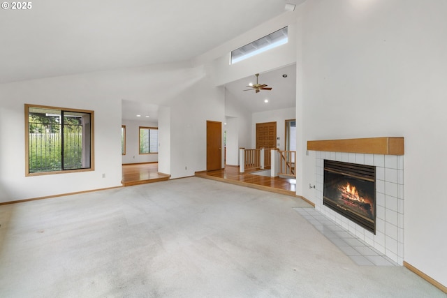 2305 Chickadee Ct, West Linn, OR 97068 - unfurnished living room with high vaulted ceiling, carpet flooring, a tiled fireplace, a ceiling fan, and baseboards