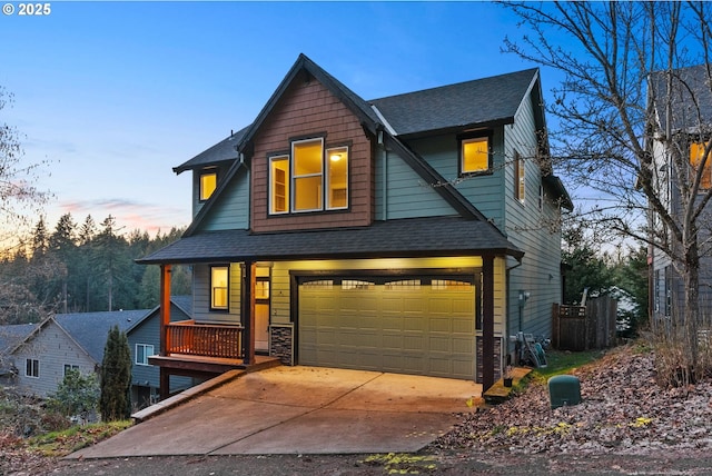 view of front of home with concrete driveway, an attached garage, and roof with shingles