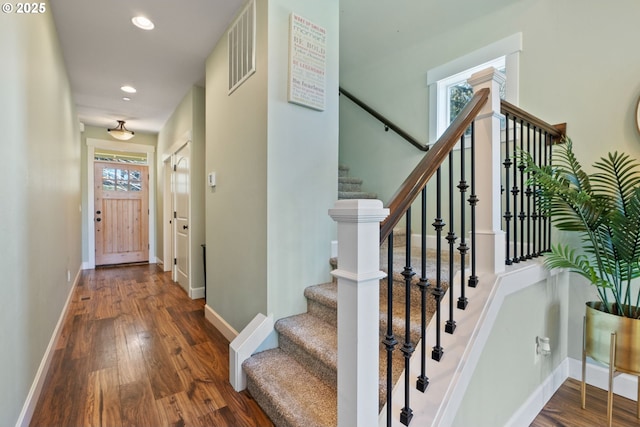 foyer entrance featuring wood finished floors, visible vents, and baseboards