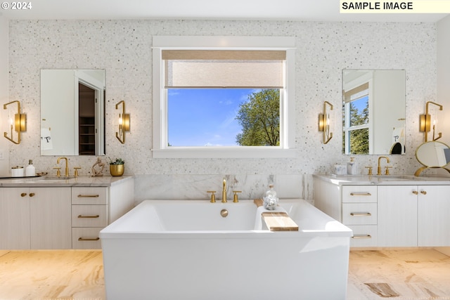 full bathroom featuring a freestanding tub, two vanities, and a sink