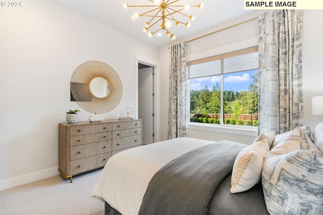 carpeted bedroom with a notable chandelier and baseboards