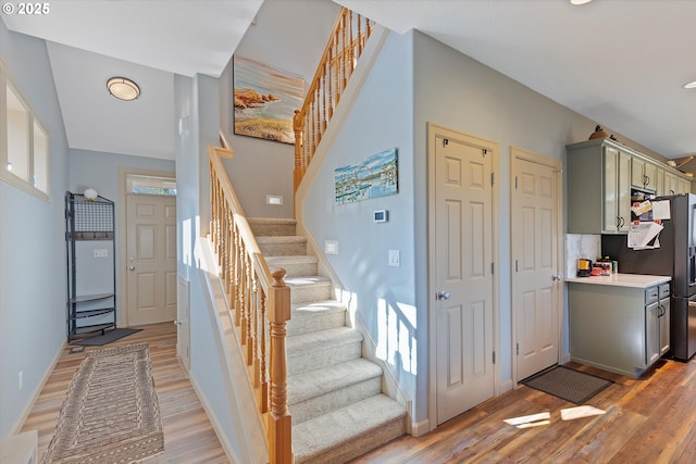 stairs with wood finished floors and baseboards