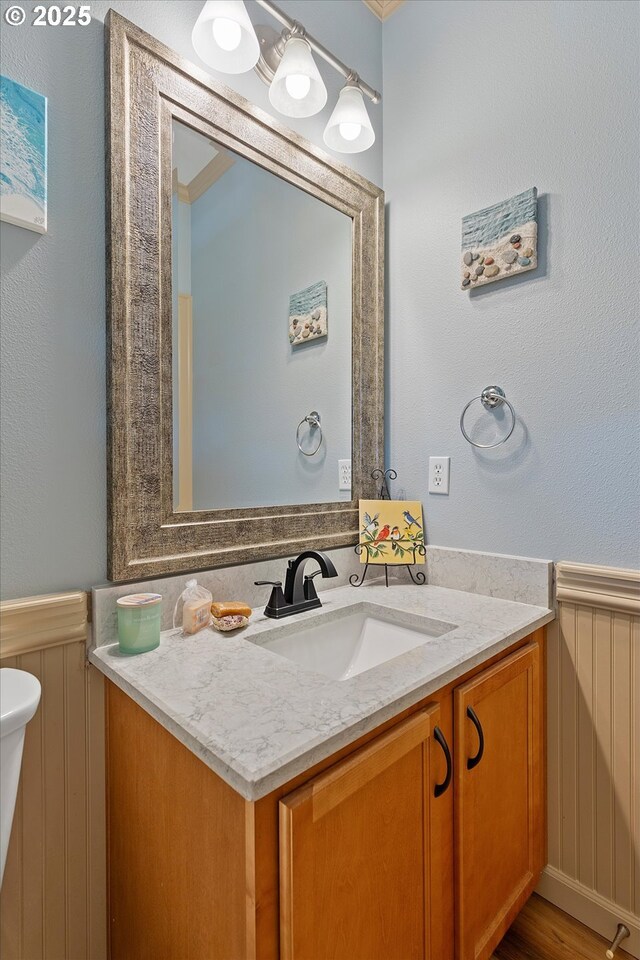 bathroom with vanity and a wainscoted wall