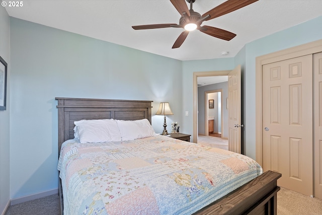 bedroom featuring light carpet, a closet, ceiling fan, and baseboards