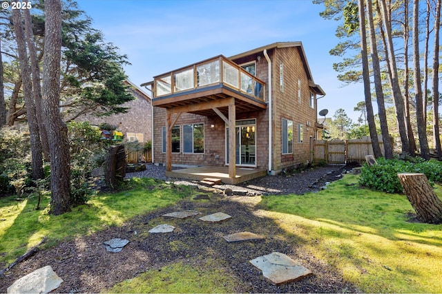 back of property featuring a yard, a fenced backyard, a wooden deck, and a patio area