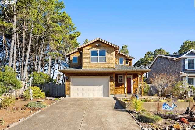 view of front facade with concrete driveway, fence, and an attached garage