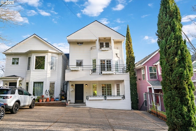 view of front of property with a balcony and fence