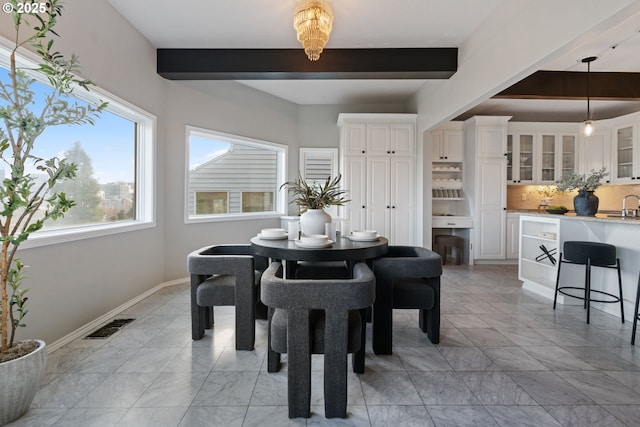 dining space featuring beam ceiling, baseboards, and visible vents