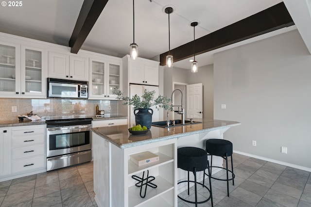 kitchen featuring beamed ceiling, a breakfast bar, a sink, backsplash, and appliances with stainless steel finishes