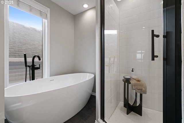 bathroom featuring a freestanding tub and a tile shower